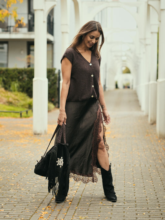 Mouwloos bruin alpaca vest gecombineerd met satijnen rok elegante bohemian look.