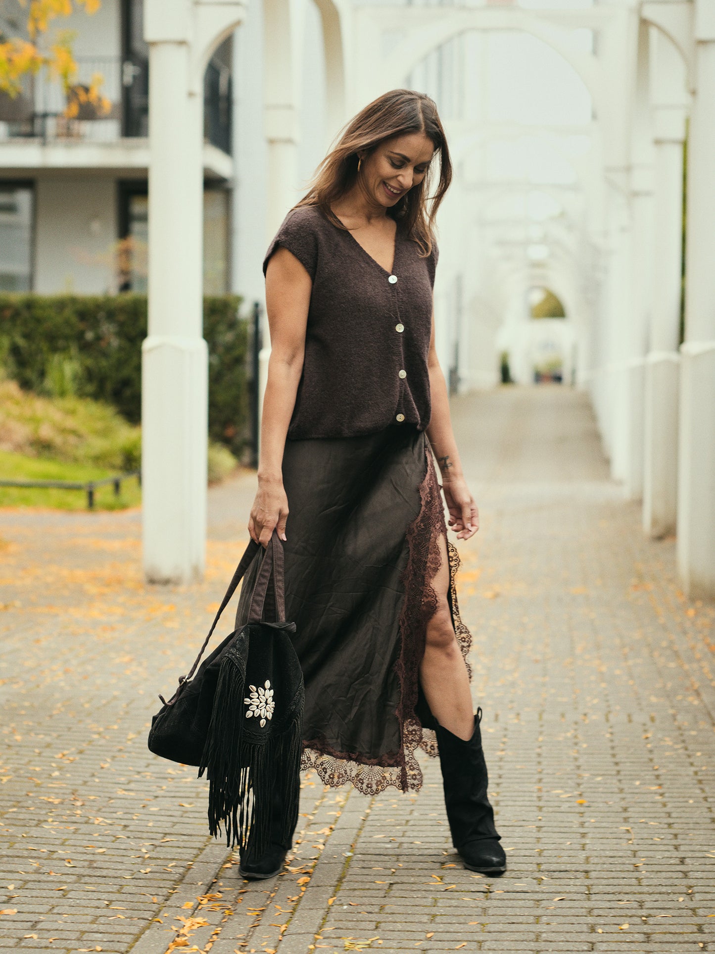 Mouwloos bruin alpaca vest gecombineerd met satijnen rok elegante bohemian look.