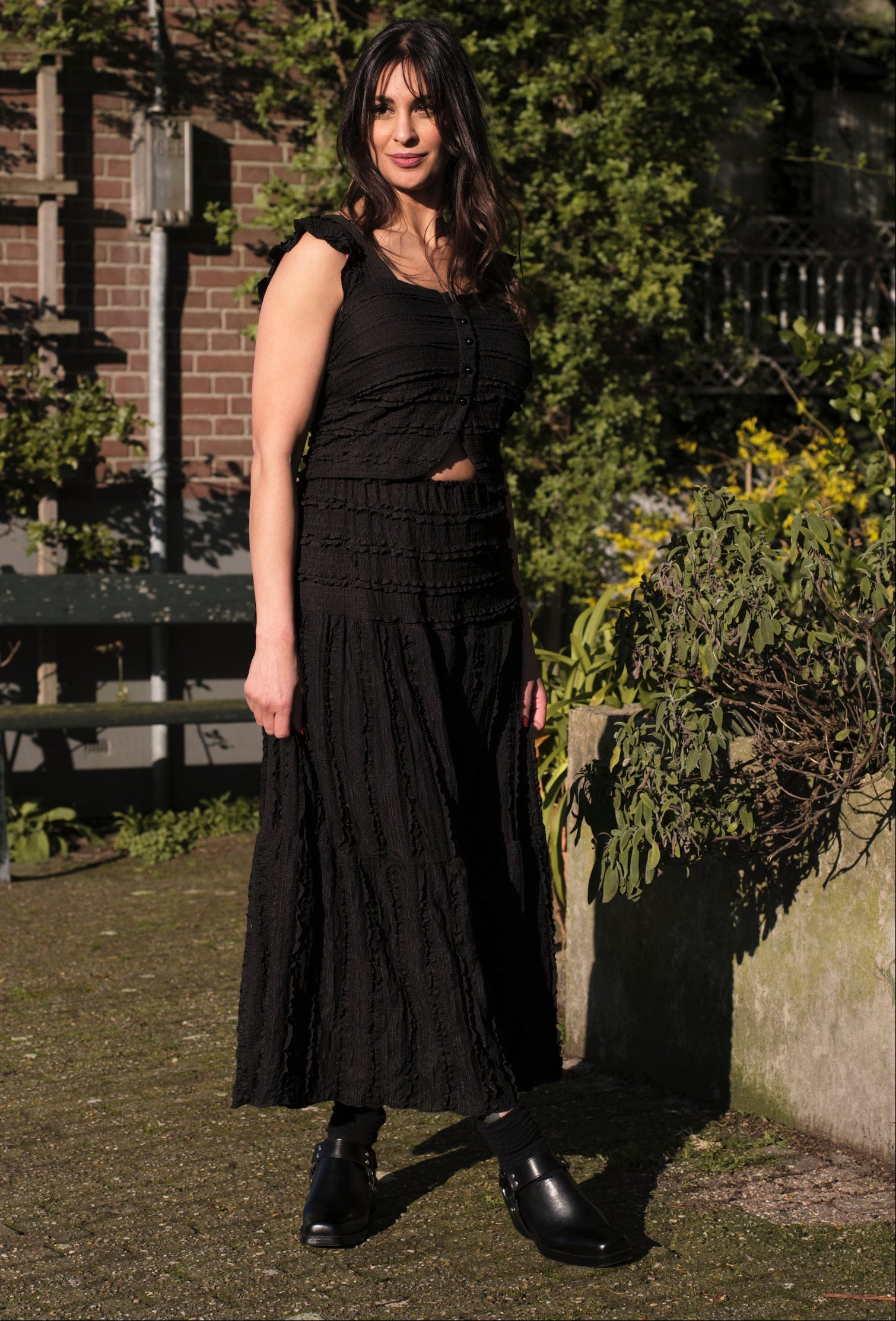 vrouw draagt zwarte rok en top set dames in zonnige straat