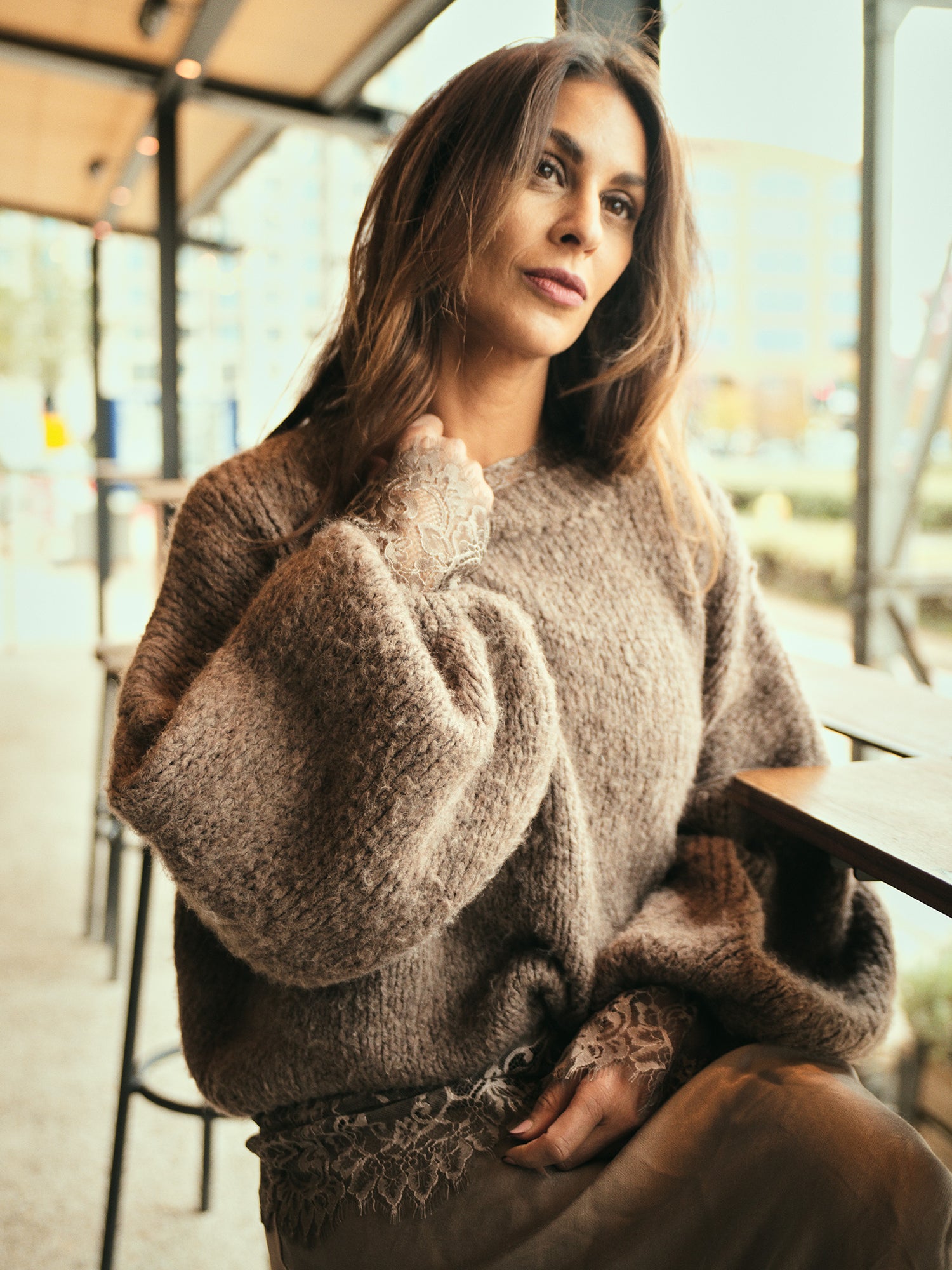 Model draagt de Kiki Goddess Trui gecombineerd met een vloeiende rok tijdens ceremonieel moment