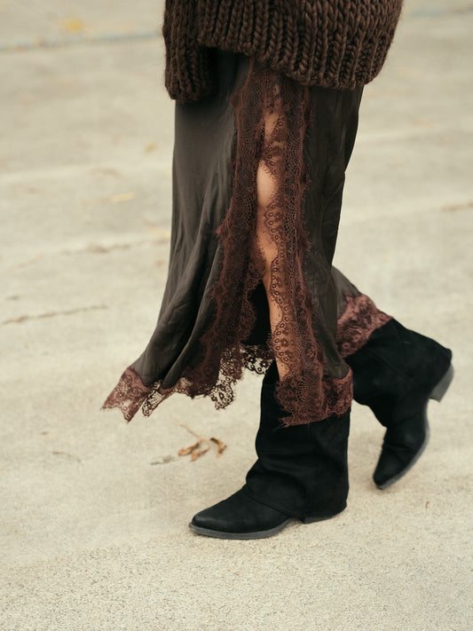 Detail van de bruine satijnen stof met kanten afwerking – bohemian en vrouwelijk