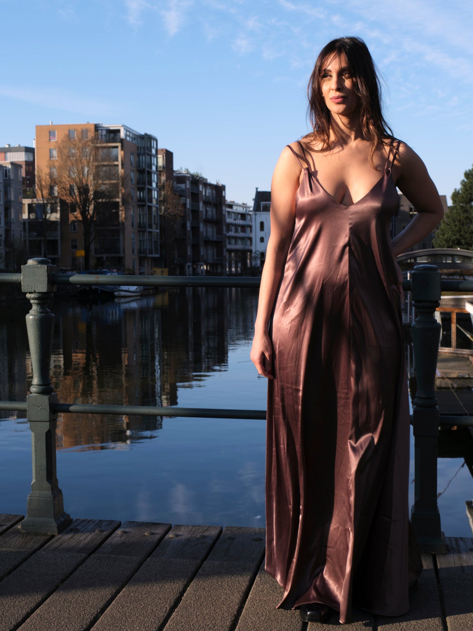 vrouw draagt satijnen jurk dames met open rug bij water