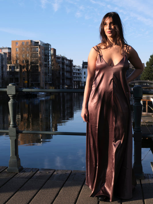 vrouw draagt satijnen jurk dames met open rug bij water