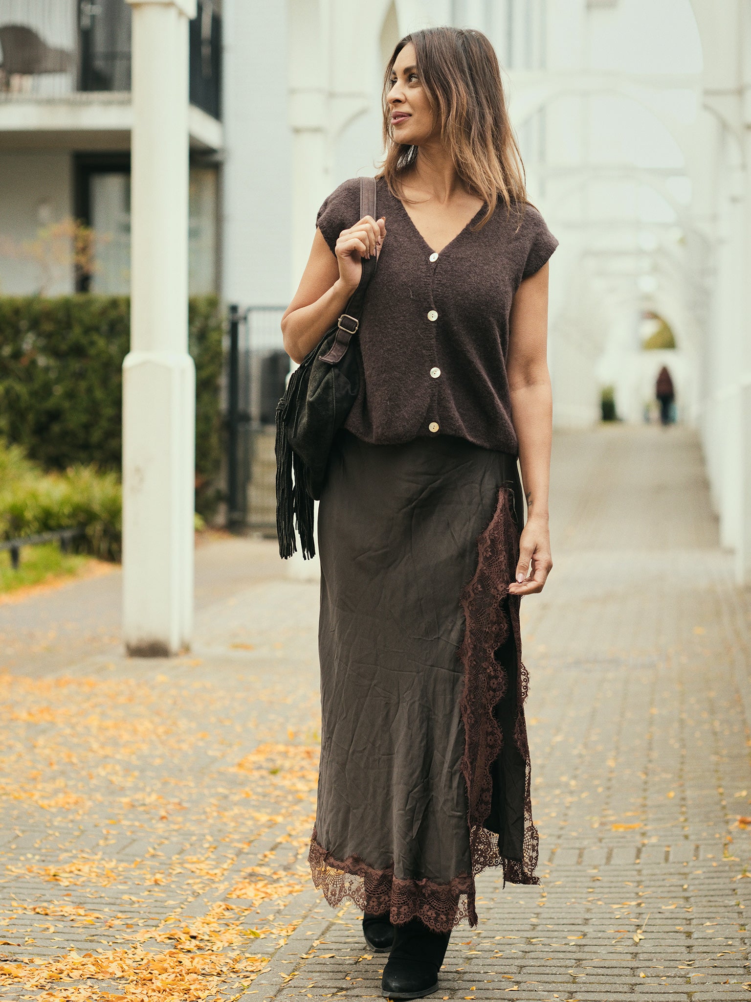 Model draagt de bruine Silk Goddess Split Skirt van Tesoros de Mujer, satijnen rok met kanten split.